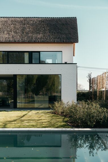 MasterPatio Coulissants, SlimLine 38 Fenêtres et SlimLine 38 HI Fenêtres - Villa avec toit de chaume et fenêtres au look acier situé à Sint-Niklaas, Belgique