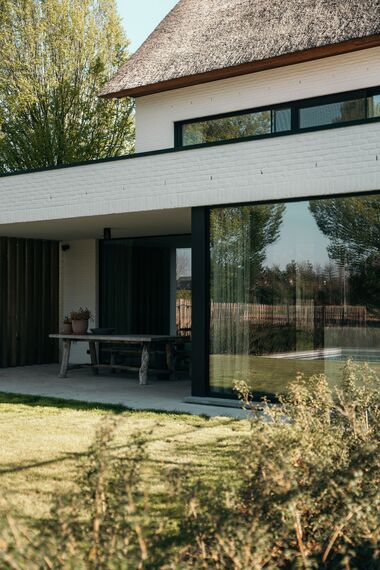 MasterPatio Coulissants, SlimLine 38 Fenêtres et SlimLine 38 HI Fenêtres - Villa avec toit de chaume et fenêtres au look acier situé à Sint-Niklaas, Belgique