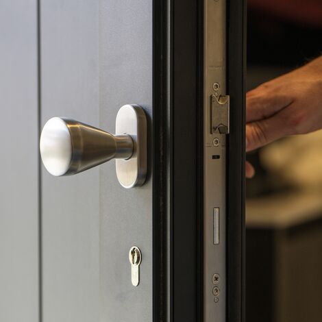 Gros plan de la poignée de porte et de la serrure de la porte extérieure en aluminium