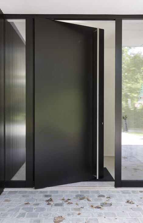 Zwarte aluminium voordeur op een kier