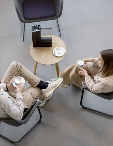 Vue de dessus d’un homme et d’une femme assis à une table, buvant du café.