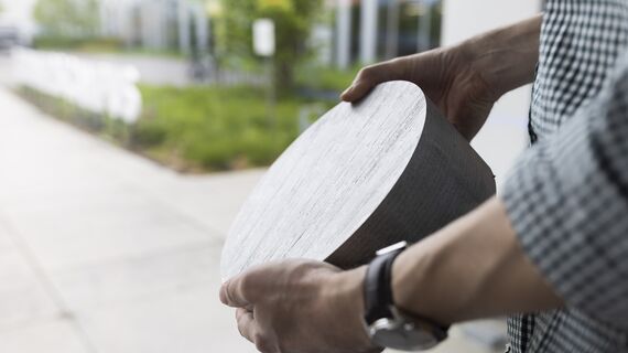 Personne tenant un matériau circulaire en billette d’aluminium.