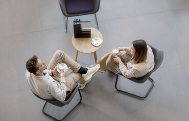 Vue de dessus : homme et femme assis à table en train de boire du café.